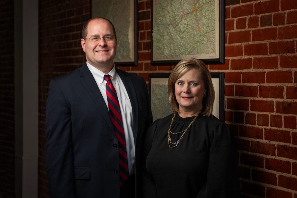 "Portrait of Scott and Laura Lloyd, attorney at Lloyd Legal LLC, wearing a suit and tie, exuding confidence and professionalism."